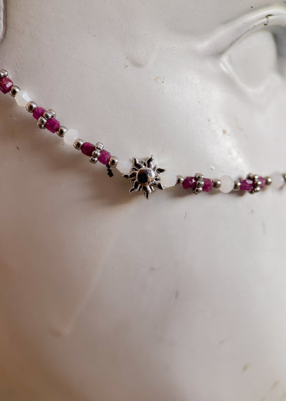 Bijou facial en rubis non raffiné et acier inoxydable avec soleils argentés. Accessoire solaire pour look boho tribal, rituel ou festival.