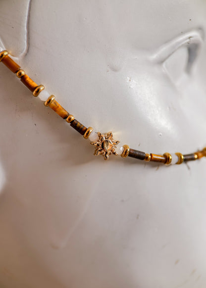 Bijou facial acier inoxydable doré, œil de tigre et howlite blanche avec détails soleil. Accessoire solaire et mystique, parfait pour festival ou événement.