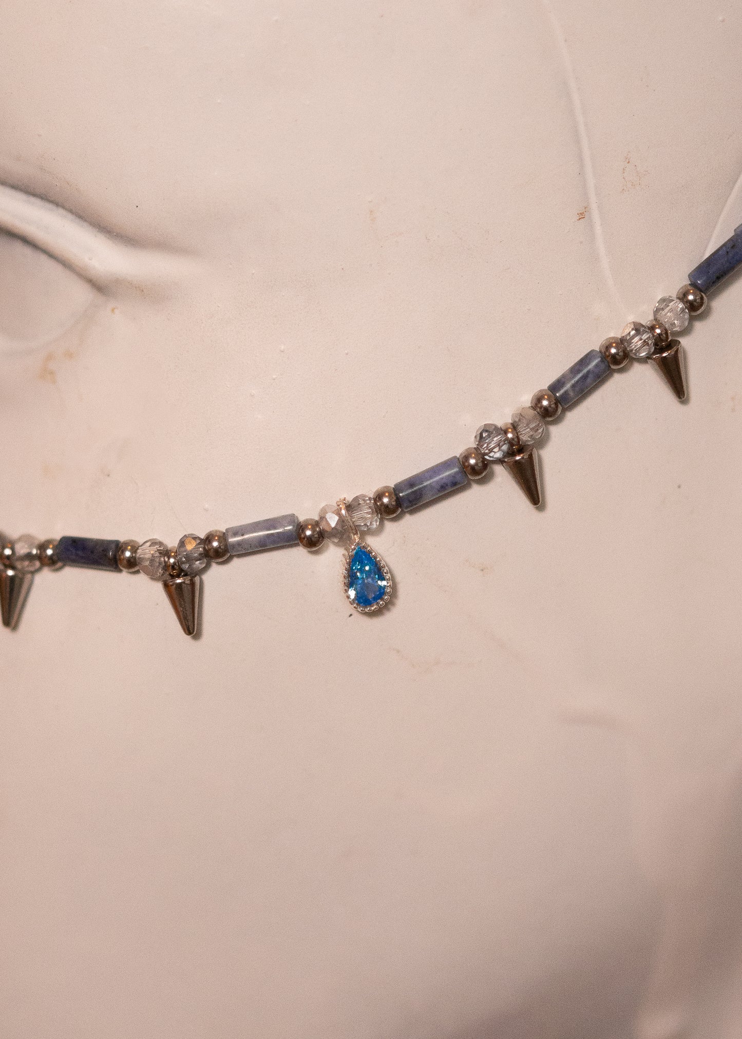 Chaîne de visage en sodalite avec zircon serti et piques acier. Bijou facial sculptural et affirmé, idéal pour look goth, nordique ou alternatif.