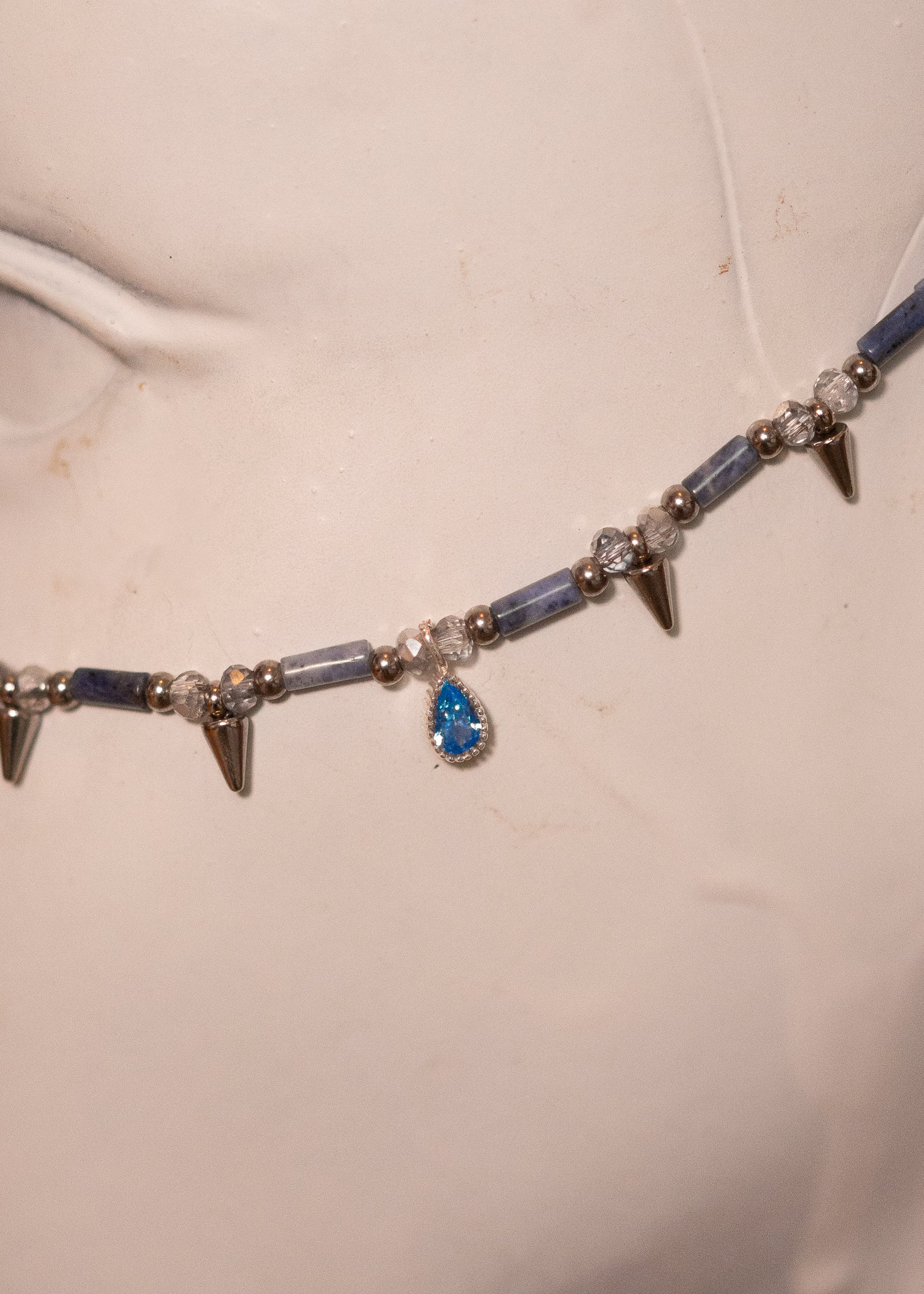 Chaîne de visage en sodalite avec zircon serti et piques acier. Bijou facial sculptural et affirmé, idéal pour look goth, nordique ou alternatif.