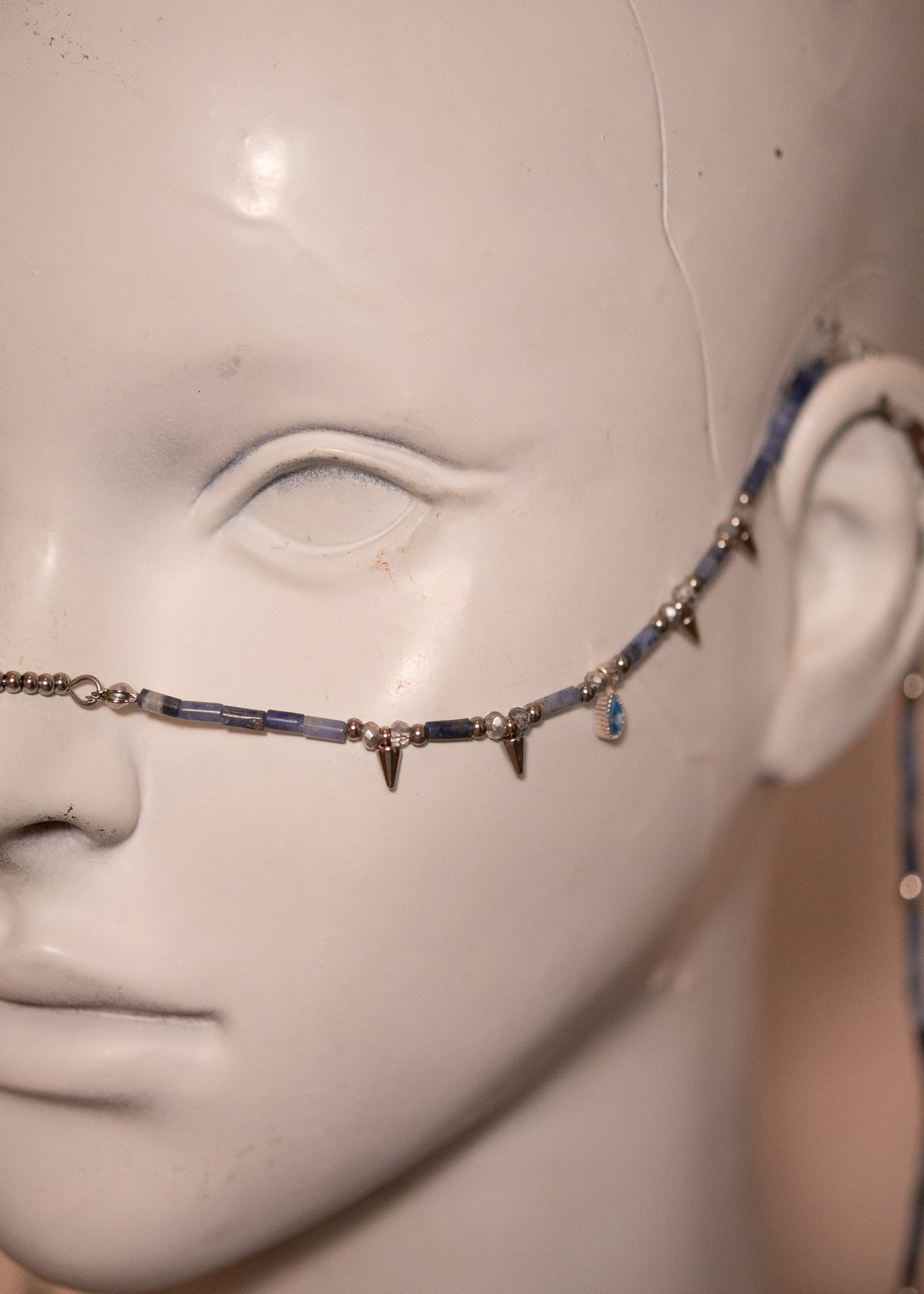Chaîne de visage en sodalite avec zircon serti et piques acier. Bijou facial sculptural et affirmé, idéal pour look goth, nordique ou alternatif.