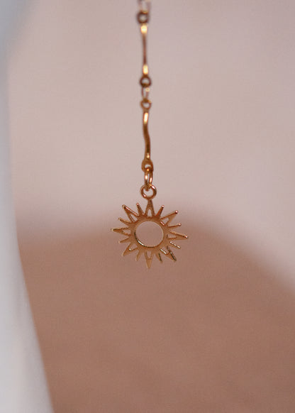 Chaîne de visage dorée fine en vaguelettes avec soleils. Bijou lumineux, look bohème chic et solaire, inspiration orientale.