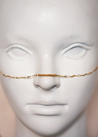 Chaîne de visage dorée fine en vaguelettes avec soleils. Bijou lumineux, look bohème chic et solaire, inspiration orientale.