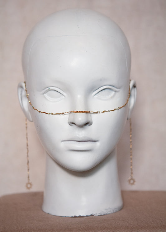 Chaîne de visage dorée fine en vaguelettes avec soleils. Bijou lumineux, look bohème chic et solaire, inspiration orientale.