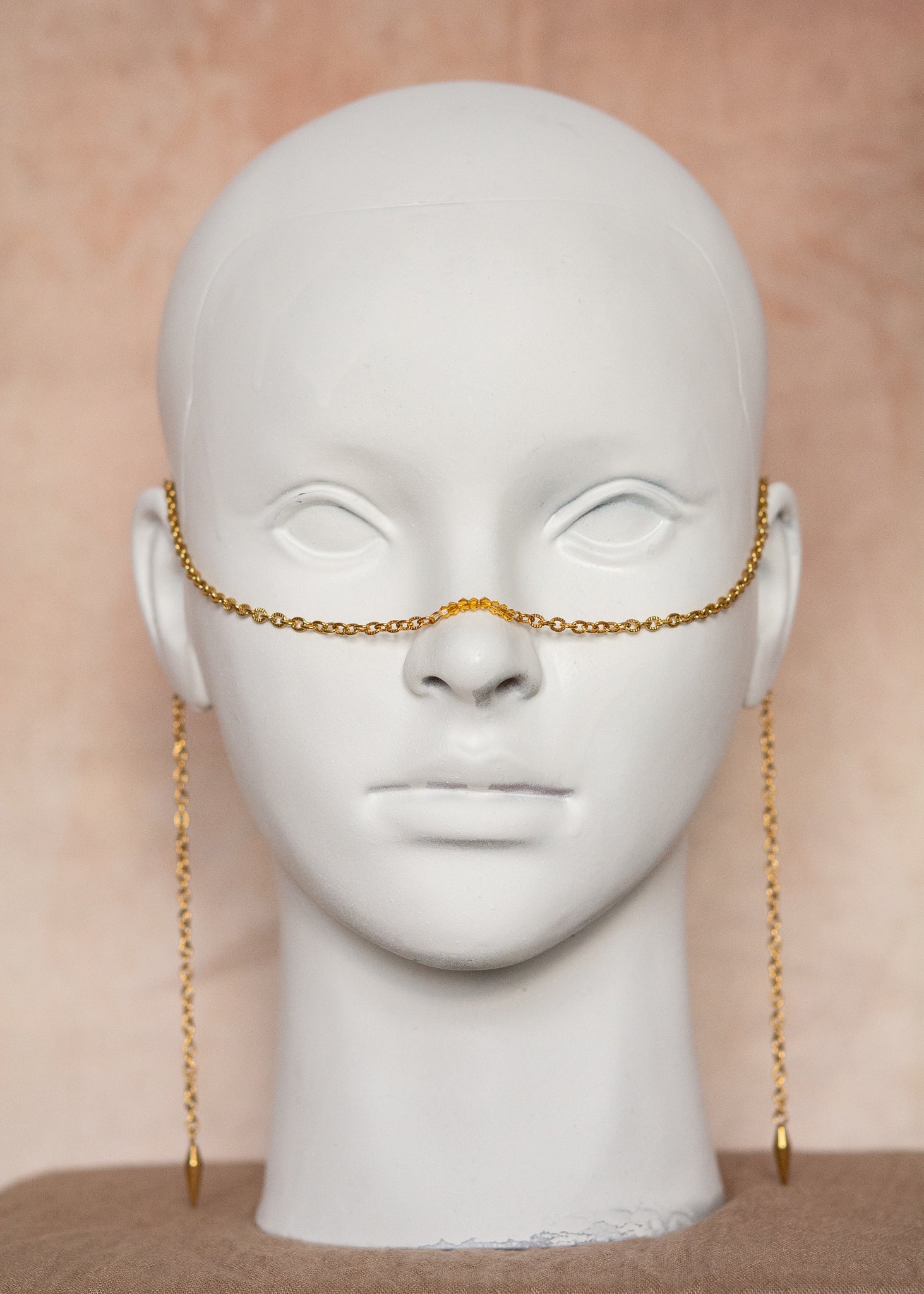 Chaîne de visage en acier inoxydable plaqué or avec cristaux ocre orangé et piques dorées. Bijou facial festival, look solaire chaud et intense.