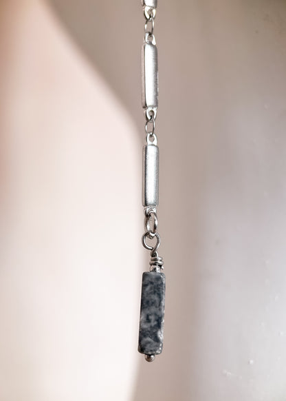 Chaîne de visage en acier inoxydable argenté à rectangles géométriques avec jaspe paysage gris. Bijou facial architectural, look minéral moderne.