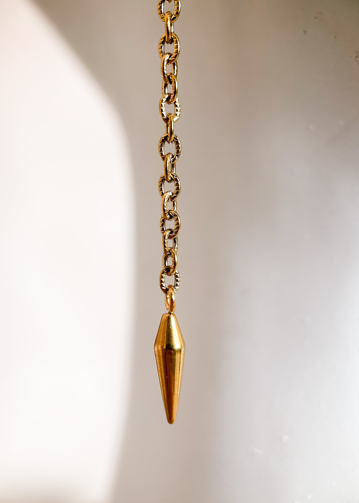 Chaîne de visage en acier inoxydable plaqué or avec cristaux ocre orangé et piques dorées. Bijou facial festival, look solaire chaud et intense.