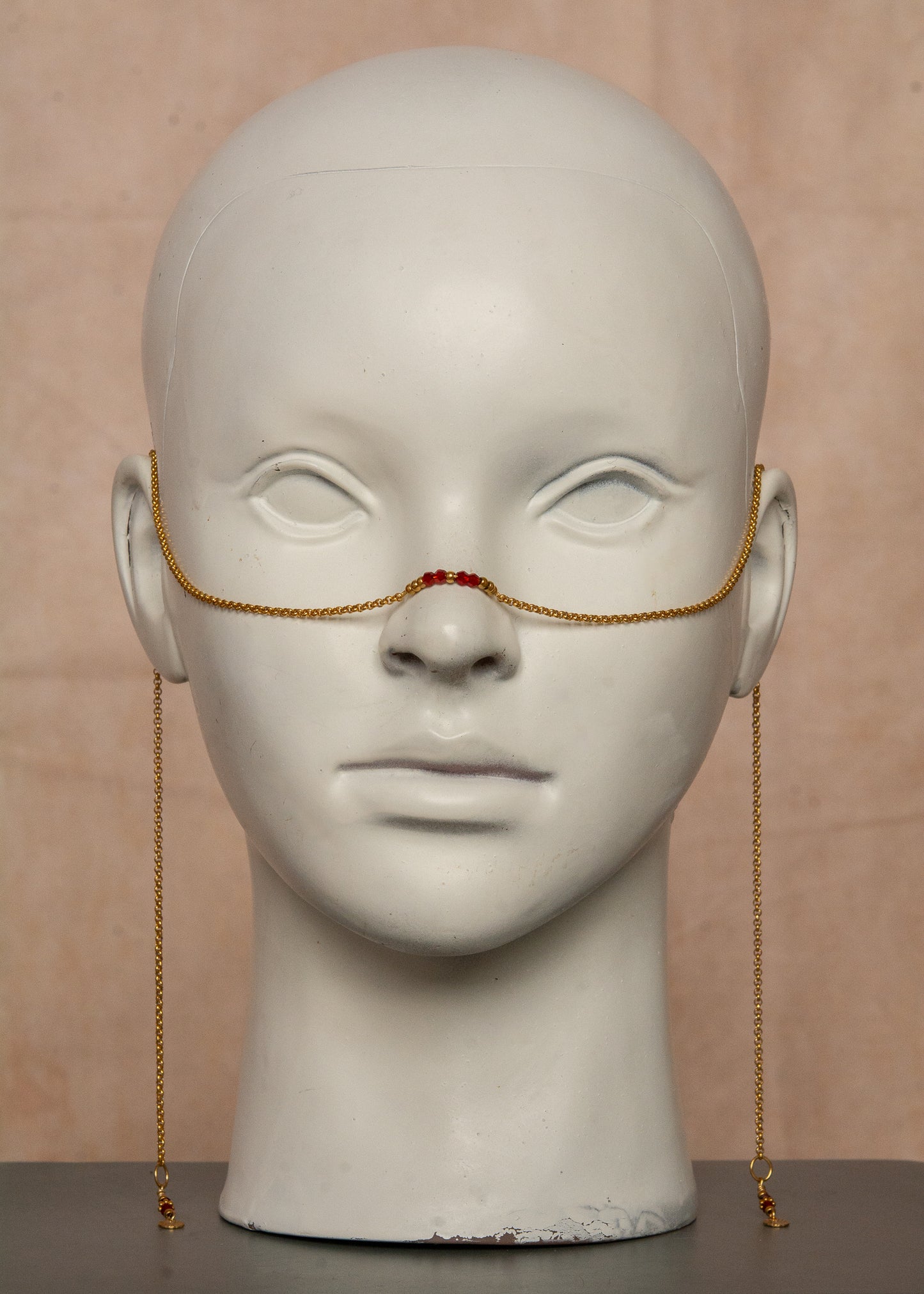 Chaîne de visage dorée en acier inoxydable, ornée de cristaux rouges et de breloques bohèmes. Un bijou audacieux inspiré du feu et de la passion, parfait pour un look flamboyant et affirmé. Accessoire original pour festivals et événements.
