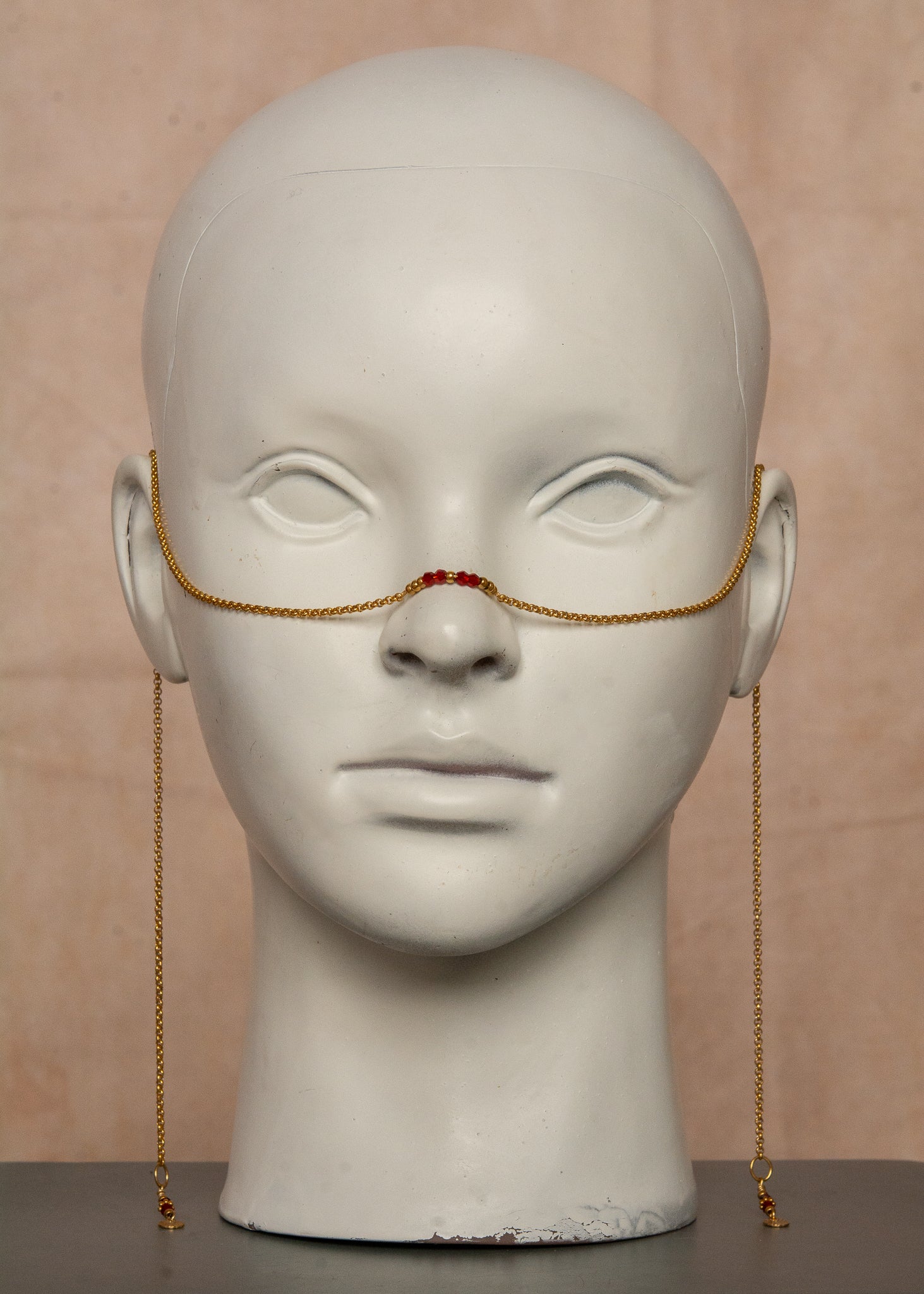 Chaîne de visage dorée en acier inoxydable, ornée de cristaux rouges et de breloques bohèmes. Un bijou audacieux inspiré du feu et de la passion, parfait pour un look flamboyant et affirmé. Accessoire original pour festivals et événements.