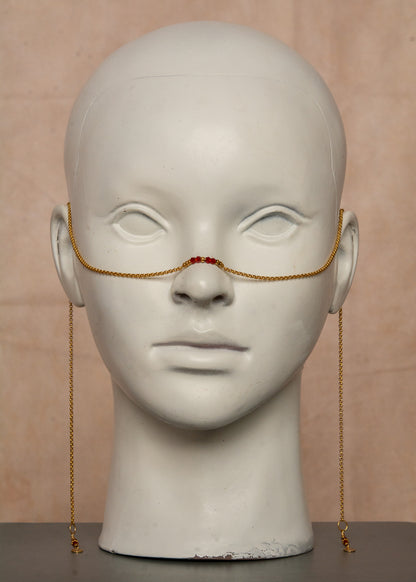 Chaîne de visage dorée en acier inoxydable, ornée de cristaux rouges et de breloques bohèmes. Un bijou audacieux inspiré du feu et de la passion, parfait pour un look flamboyant et affirmé. Accessoire original pour festivals et événements.