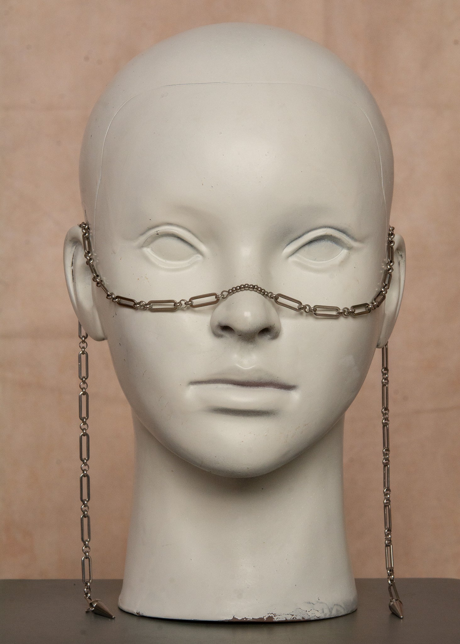 Bijou facial guerrier inspiré des Valkyries nordiques. Chaîne géométrique robuste en acier inoxydable avec bridge adaptable orné de billes métalliques. Accessoire unisexe ajustable idéal pour festivals, événements à thème médiéval ou looks audacieux.