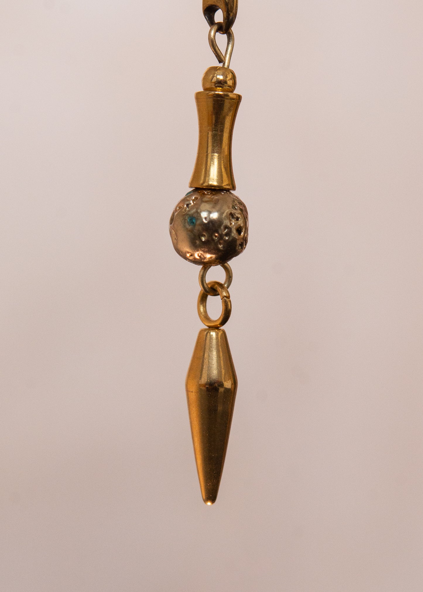 Chaîne de visage en acier inoxydable, assemblée à la main dans un motif de côte-de-maille avec perles tubes blanches et perles de lave dorées. Bijou mystique et guerrier, parfait pour les festivals et événements, ou pour ajouter une touche orientale à un look audacieux.