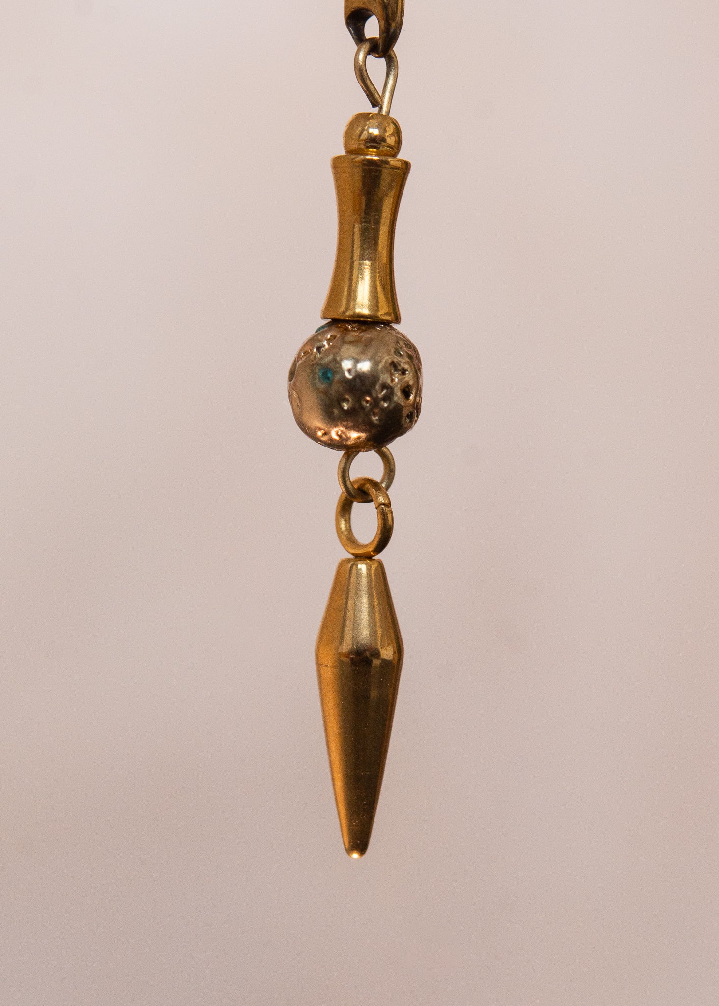 Chaîne de visage en acier inoxydable, assemblée à la main dans un motif de côte-de-maille avec perles tubes blanches et perles de lave dorées. Bijou mystique et guerrier, parfait pour les festivals et événements, ou pour ajouter une touche orientale à un look audacieux.