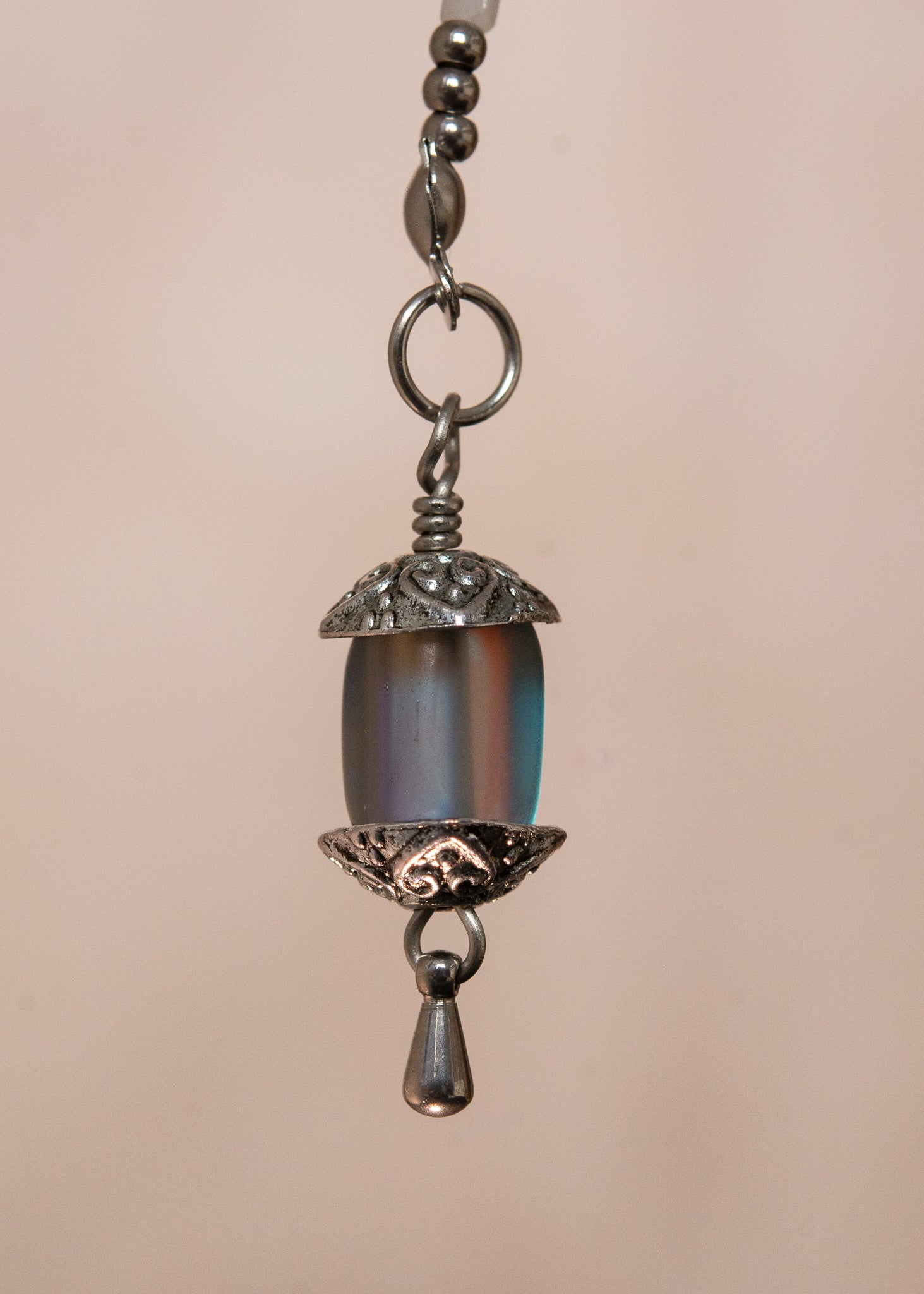 Bijou facial artisanal combinant agate blanche, cristaux bleus et acier inoxydable. Accessoire céleste avec charmes étoiles et pierres de lune noires aux reflets holographiques transformées en lanternes orientales. Pièce unique apportant sérénité et équilibre, parfaite pour festivals nocturnes et événements mystiques.