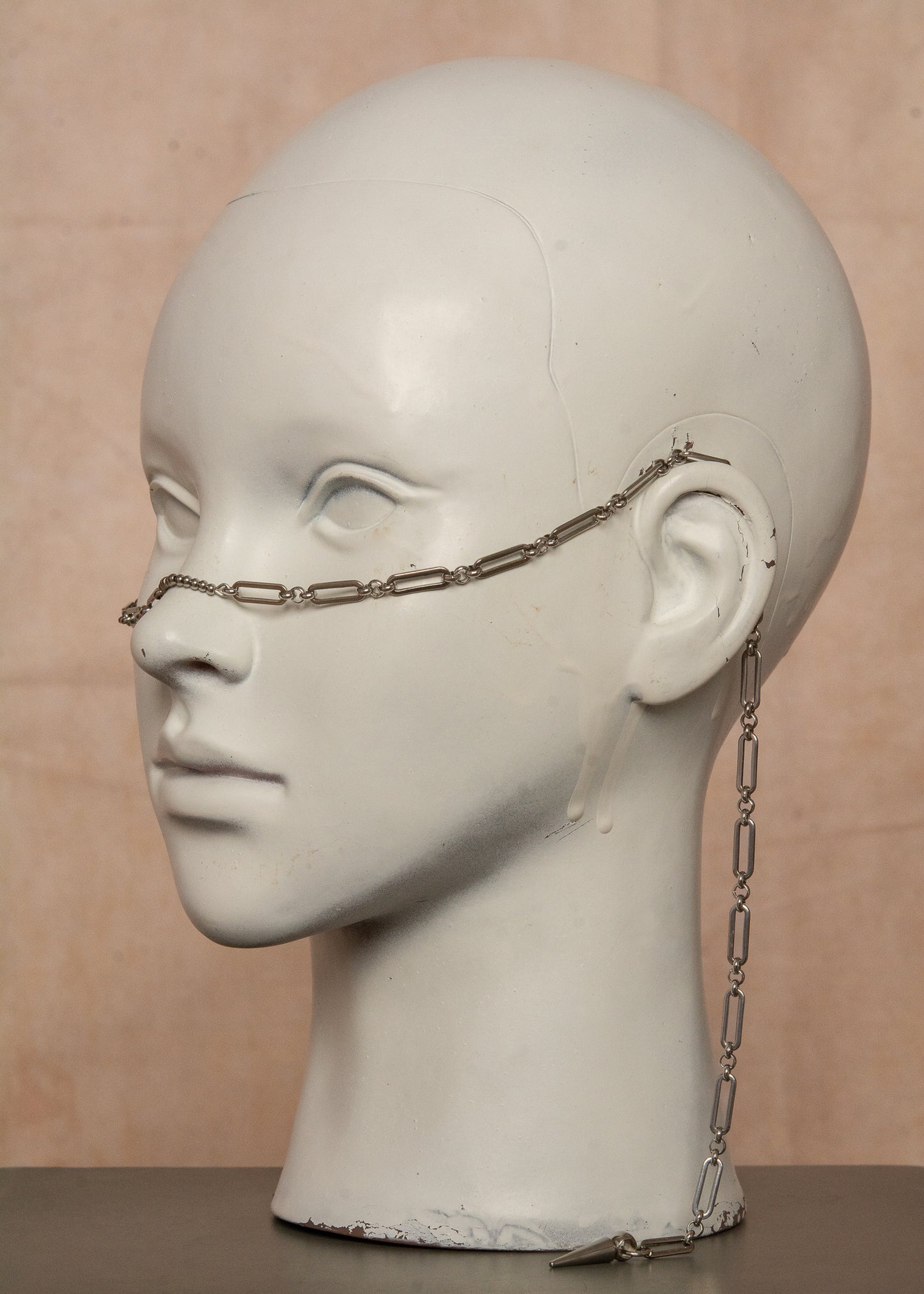 Bijou facial guerrier inspiré des Valkyries nordiques. Chaîne géométrique robuste en acier inoxydable avec bridge adaptable orné de billes métalliques. Accessoire unisexe ajustable idéal pour festivals, événements à thème médiéval ou looks audacieux.
