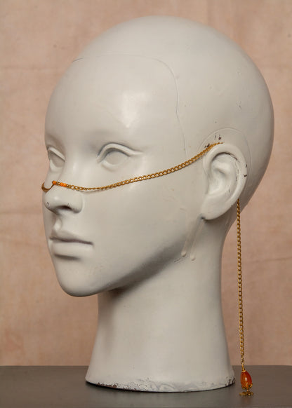 Chaîne de visage dorée inspirée de l’éclat du soleil, ornée de pierres d’agate orange et charms soleil bohème. Bijou facial unisexe en acier inoxydable, parfait pour festivals, tenues audacieuses et événements spéciaux.